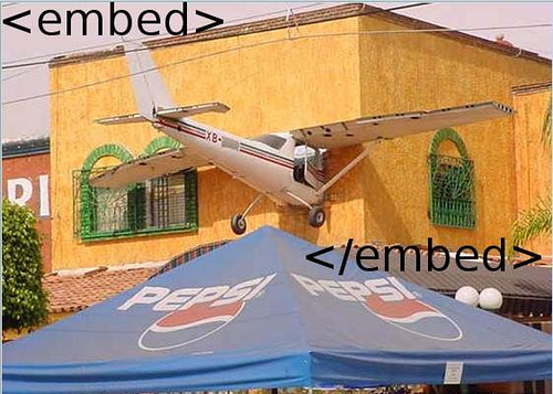 illustrasjonsfoto - et småfly krasjet inn i en husvegg, flyet er rammet inn av embed-kode