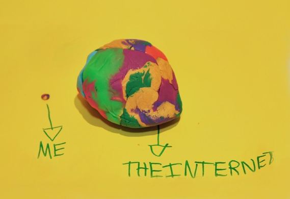 Barnekunst med en liten enkel plastilinakule med en pil ned til teksten "ME" ved siden av en stor mangefarget plastilinakule med en pil ned til teksten "The Internet"