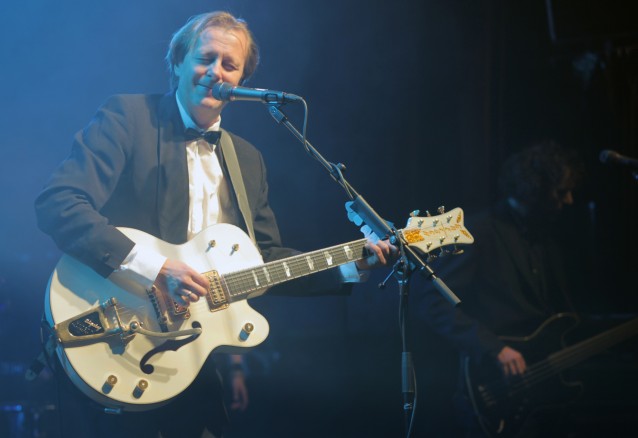 Lars Lillo-Stenberg på scenen spillende på en hvit gitar