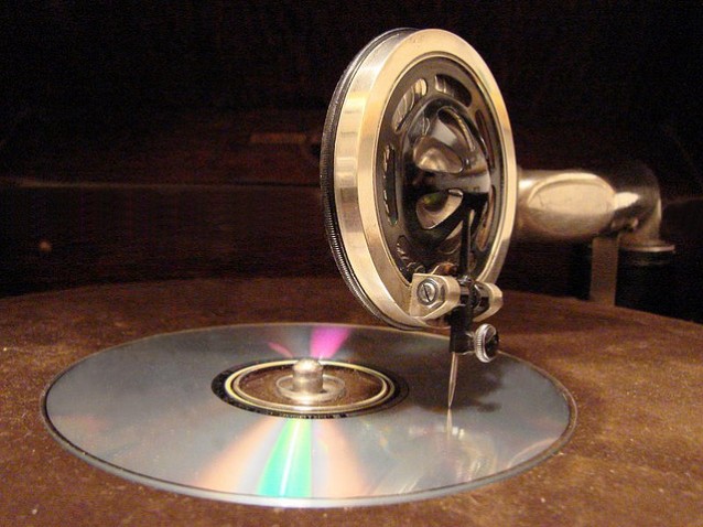 en CD-plate liggende på en mekanisk 78-platespiller med nålen mot CD'en