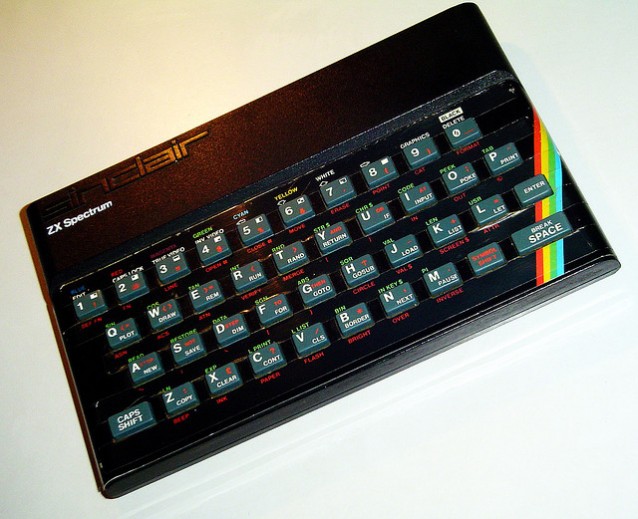 en sort liten computer fra 80-tallet med regnbuestripe og grå gummitaster