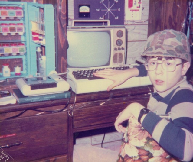 En litt geekete gutt, ca 13 år, på rommet sitt med en Commodore Vic 20, kjemisett og vindmåler-display