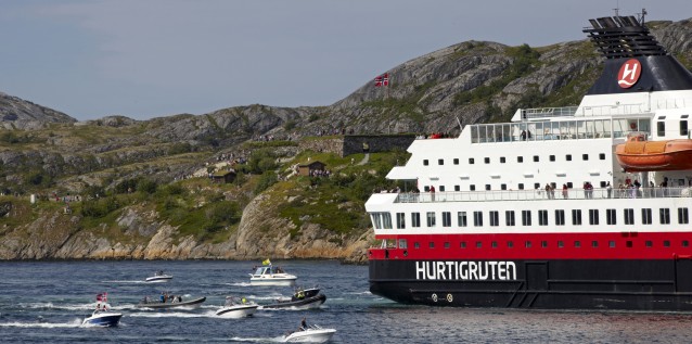 Hurtigruten Nordnorge med en stim av småbåter etter