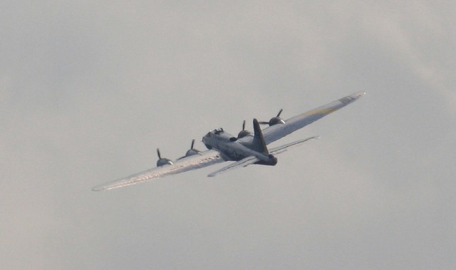 Et bombefly fra 2. verdenskrig eller deromkring mot en grå himmel, på vei vekk fra kamera