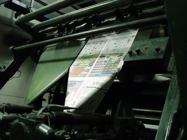 En avis på vei ut av en trykkpresse