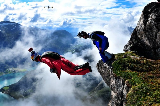 To menn i wingsuits som hopper fra en fjelltopp i Flo
