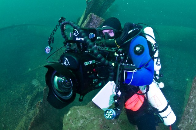 En dykker med kamera og rebreather fotografert under vann.