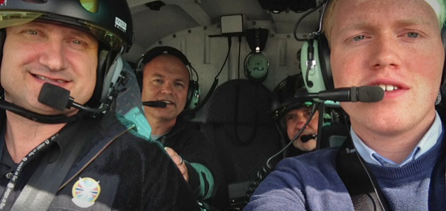 Foto av fire menn i et helikopter