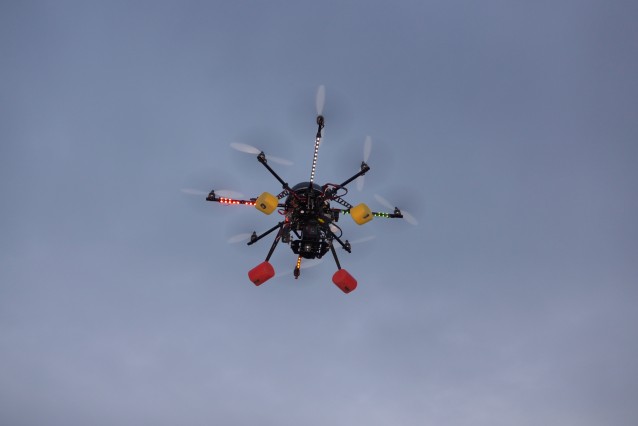 En drone med åtte rotorer fotografert i luften. 