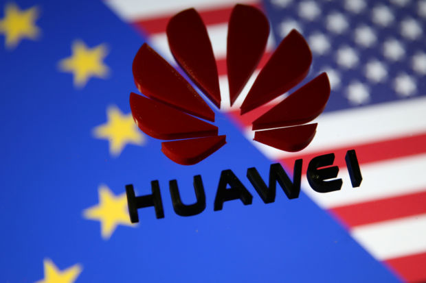 A 3D printed Huawei logo is placed on glass above displayed EU and US flags in this illustration taken January 29, 2019.