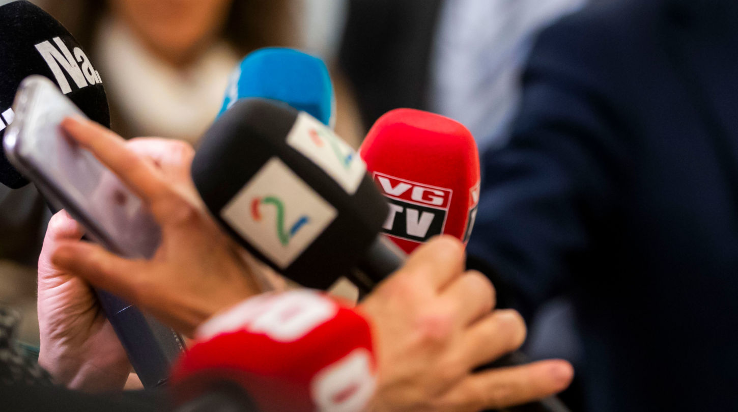 Flere mikrofoner med logoene til Dagbladet, TV2, VG, Nettavisen og NRK samlet under et intervju
