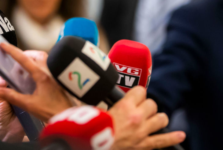 Flere mikrofoner med logoene til Dagbladet, TV2, VG, Nettavisen og NRK samlet under et intervju