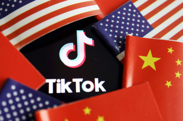 Kinesiske og amerikanske flagg omkranser logoen til TikTok