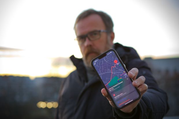 Eirik Solheim med telefonen som viser nøyaktig spor for hvor han har vert på et kart.