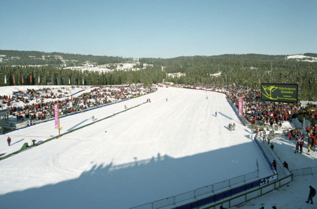 Et bilde av Birkebeineren skistadion med mange mennesker på tribunene og snø i løypa.